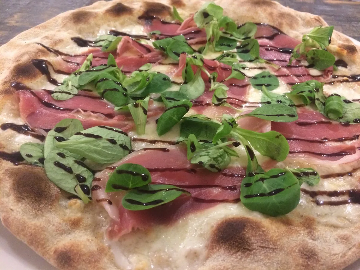 Pizza con prosciutto crudo, valeriana e glassa al balsamico